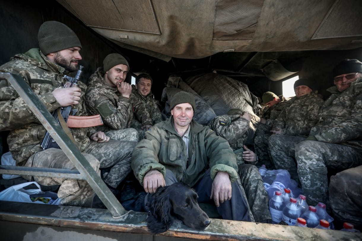 Militares de las Fuerzas Armadas de Ucrania sentados en la parte trasera de un camión militar en la ciudad de Avdiivka, en la región de Donetsk, en la línea del frente con los separatistas apoyados por Rusia, el 21 de febrero de 2022. (Aleksey Filippov / AFP)