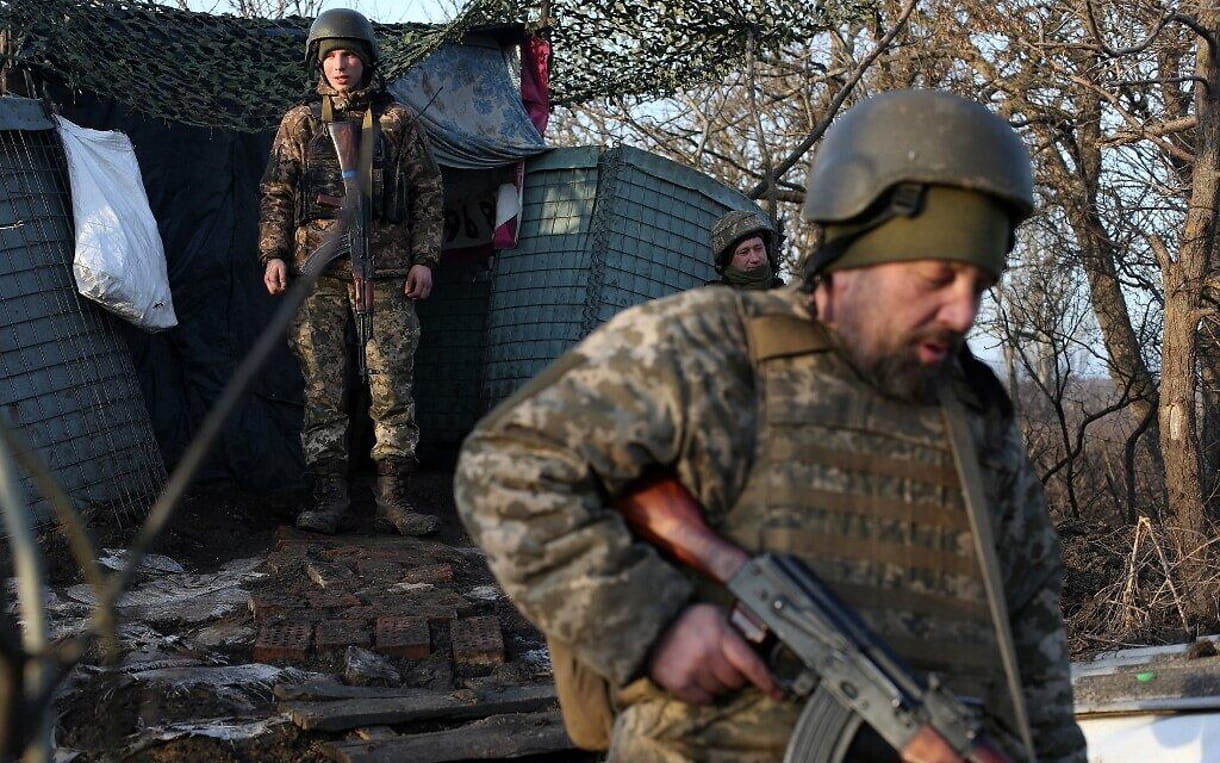 Militares de las Fuerzas Militares de Ucrania caminan en la línea del frente con los separatistas apoyados por Rusia cerca de Novohnativka, región de Donetsk, el 20 de febrero de 2022 (Anatolii STEPANOV / AFP)