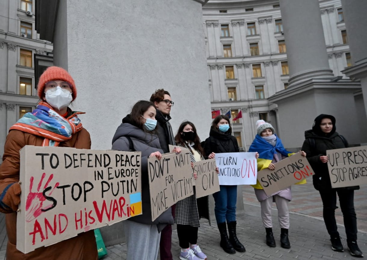 Los manifestantes sostienen pancartas exigiendo sanciones durante una concentración frente al Ministerio de Asuntos Exteriores de Ucrania en Kiev el 21 de febrero de 2022 (Sergei SUPINSKY / AFP)