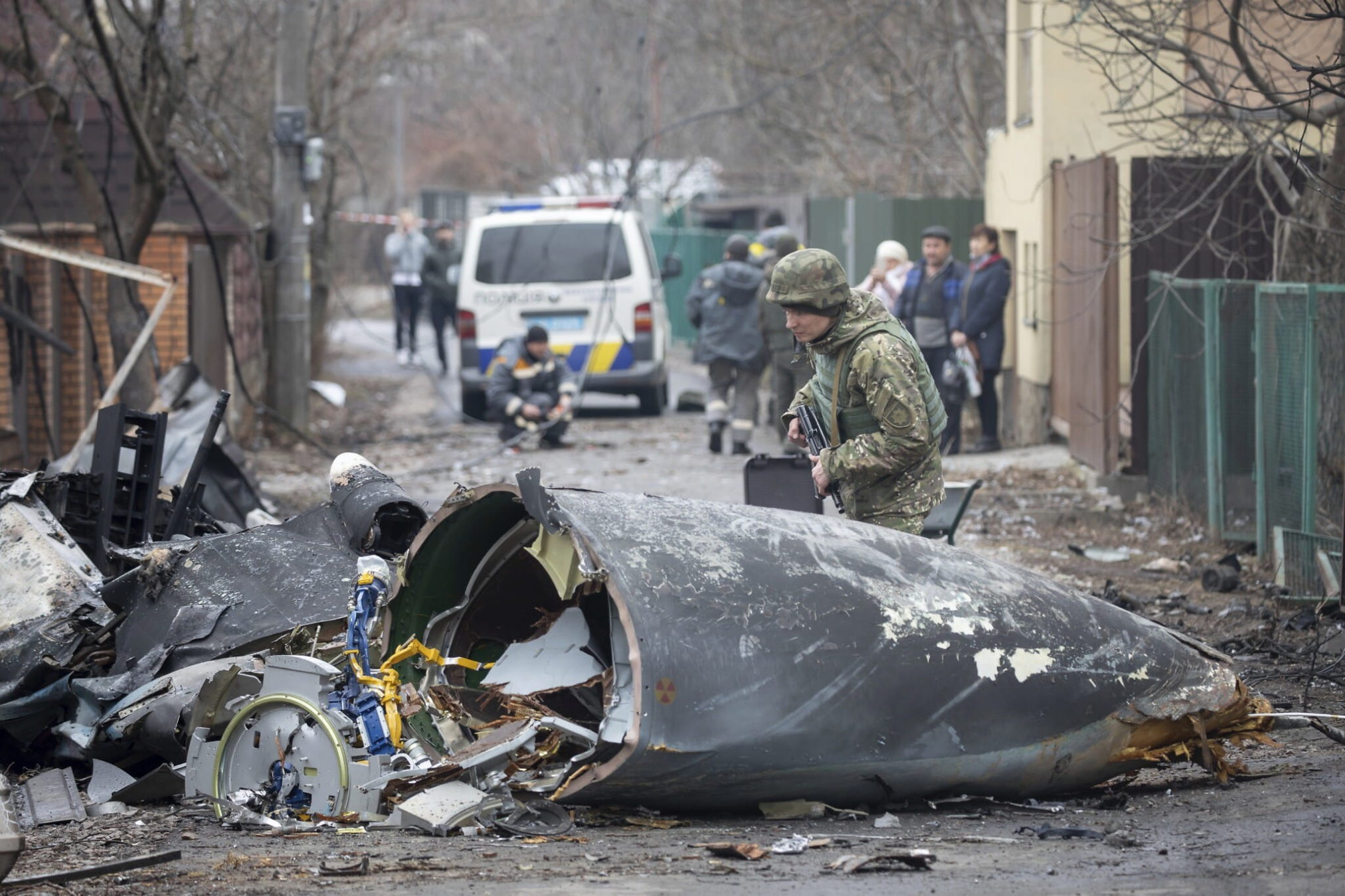 Un soldado del ejército ucraniano inspecciona fragmentos de un avión derribado en Kiev, Ucrania, el viernes 25 de febrero de 2022. No estaba claro qué avión se estrelló y qué lo hizo caer en medio de la invasión rusa en Ucrania. (AP Photo/Vadim Zamirovsky)