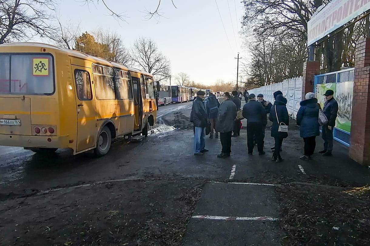 Personas junto a un autobús en la región de Rostov del Don, Rusia, a primera hora del 19 de febrero de 2022, después de evacuar Donetsk, territorio controlado por militantes prorrusos en el este de Ucrania (Foto AP)