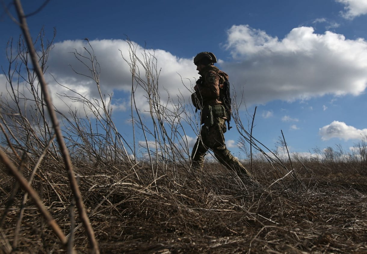 Un militar de las Fuerzas Militares de Ucrania camina en su posición en la línea del frente con los separatistas respaldados por Rusia, no lejos de la aldea de Novognativka, en la región de Donetsk, el 19 de febrero de 2022. (Anatolii STEPANOV / AFP)