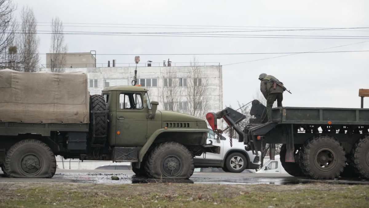 Soldados del ejército ucraniano se preparan para remolcar un camión militar dañado en Kiev, Ucrania, el viernes 25 de febrero de 2022 (AP Photo/Efrem Lukatsky)