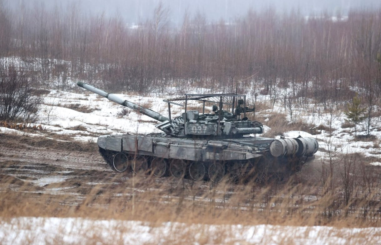 Un tanque se mueve a lo largo de un campo durante los ejercicios conjuntos de las fuerzas armadas de Rusia y Bielorrusia en un campo de tiro cerca de una ciudad de Osipovichi en las afueras de Minsk el 17 de febrero de 2022. (Maxim GUCHEK / BELTA / AFP)