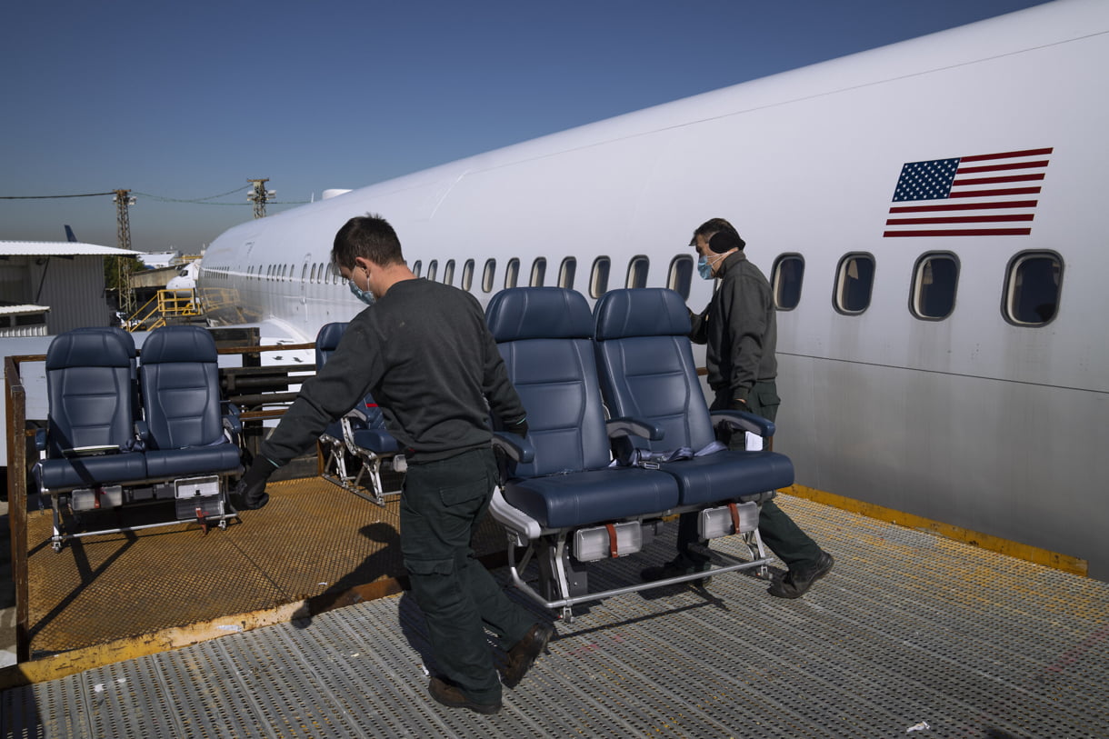 Ingenieros llevan a cabo los asientos de los pasajeros mientras trabajan en la conversión de un avión de pasajeros Boeing 767 a un avión de carga en las Industrias Aeroespaciales de Israel en Lod, cerca de Tel Aviv, Israel, el 13 de febrero de 2022. (AP Photo/Oded Balilty)