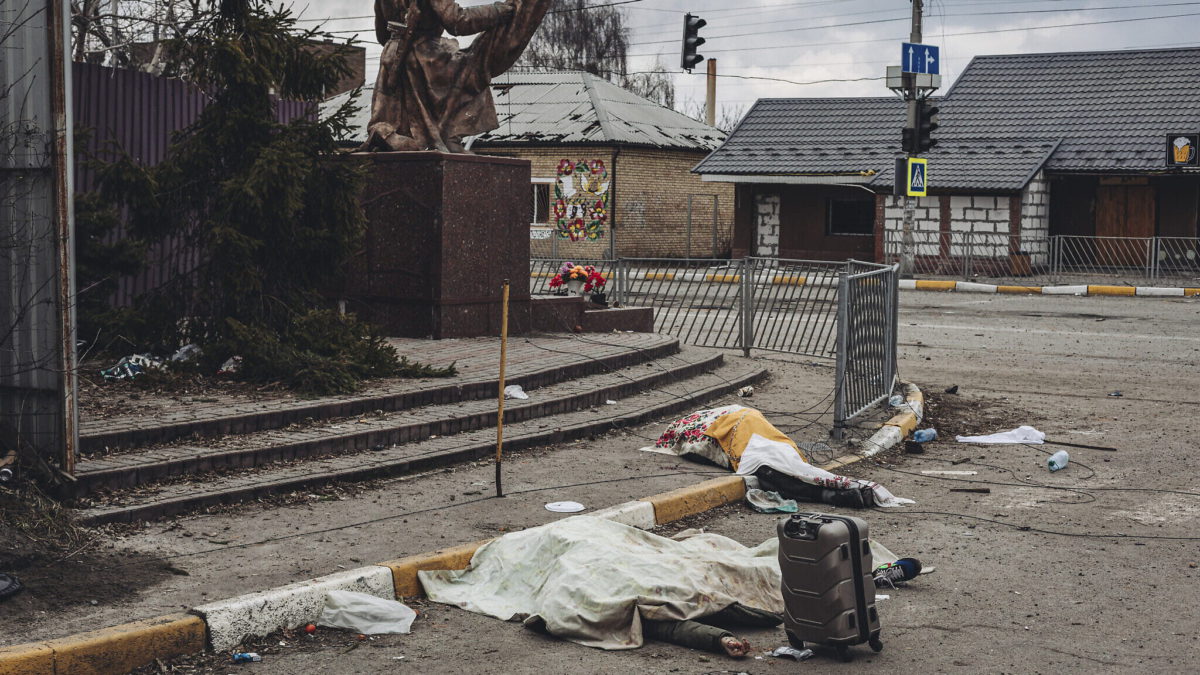 Los cadáveres de las personas muertas por los bombardeos rusos yacen cubiertos en la calle en la ciudad de Irpin, Ucrania, el 6 de marzo de 2022. (AP Photo/Diego Herrera Carcedo)
