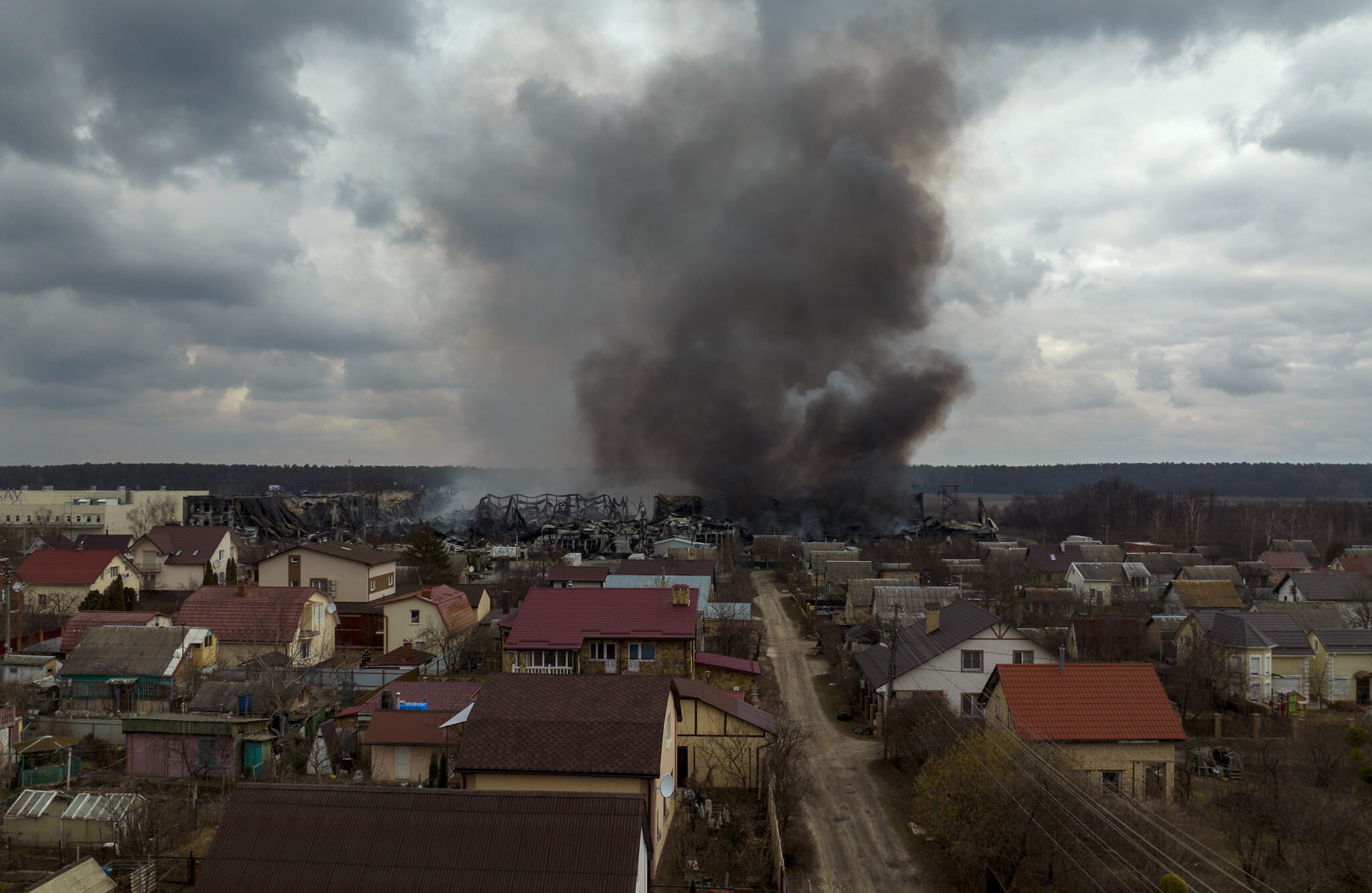 Una fábrica y una tienda arden tras ser bombardeadas en Irpin, en las afueras de Kiev, Ucrania, el 6 de marzo de 2022. (AP Photo/Emilio Morenatti)