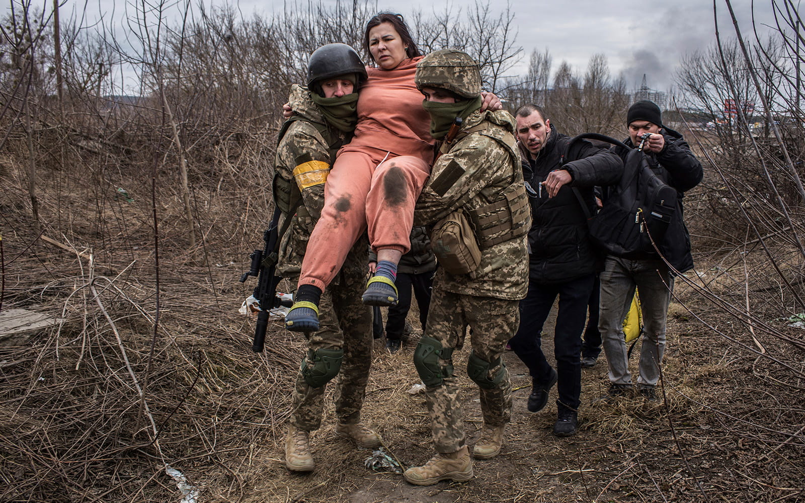 Soldados ucranianos llevan a una mujer en un camino improvisado mientras huyen de la ciudad de Irpin, Ucrania, el 6 de marzo de 2022. (AP Photo/Oleksandr Ratushniak)