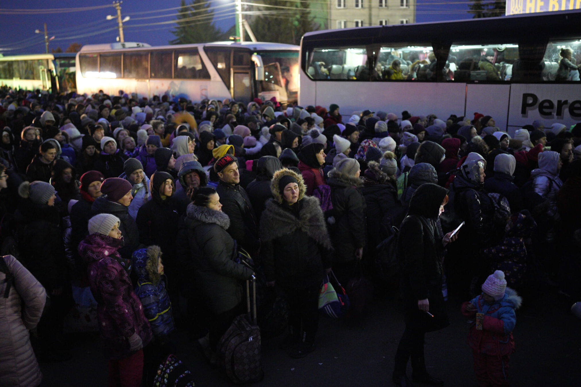 Refugiados que huyen de la guerra en Ucrania, forman una fila mientras se acercan a la frontera con Polonia en Shehyni, Ucrania, el 6 de marzo de 2022. (AP Photo/Daniel Cole)
