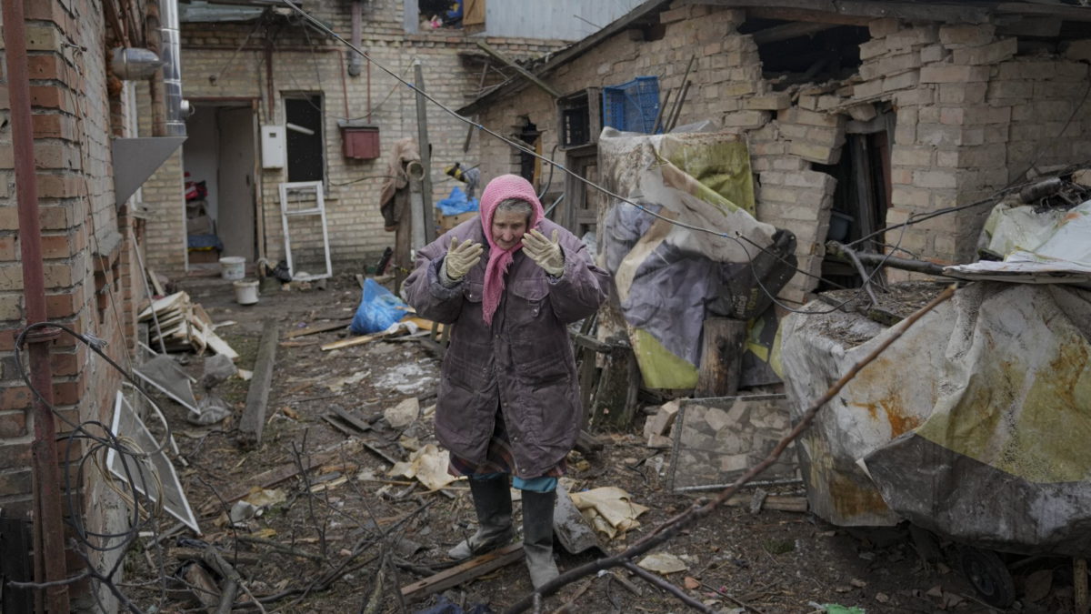 Una mujer se encuentra en el patio trasero de una casa dañada por un ataque aéreo ruso, según los lugareños, en Gorenka, a las afueras de la capital Kiev, Ucrania, el miércoles 2 de marzo de 2022 (AP Photo/Vadim Ghirda)