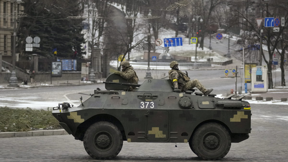 Militares ucranianos montan sobre un vehículo blindado de transporte de personal que baja a toda velocidad por un bulevar desierto durante una alarma de ataque aéreo, en Kiev, Ucrania, el martes 1 de marzo de 2022. (AP Photo/Vadim Ghirda)