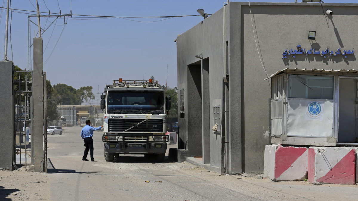 Un oficial de seguridad del grupo terrorista Hamás comprueba un camión que entra en Gaza en la puerta del cruce de carga de Kerem Shalom con Israel, en Rafah, al sur de la Franja de Gaza, el 21 de junio de 2021. (Adel Hana/AP)