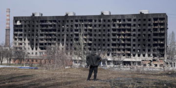 Un hombre observa un edificio de apartamentos quemado y dañado por los bombardeos en Mariupol, Ucrania, el domingo 13 de marzo de 2022. (AP/Evgeniy Maloletka)