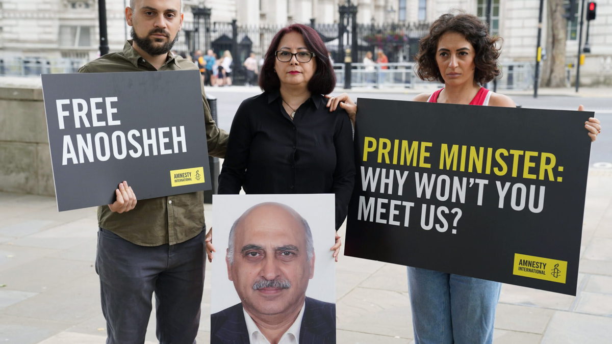 De izquierda a derecha, Aryan Ashoori, Sherry Izadi y Elika Ashoori, el hijo, la esposa y la hija de Anoosheh Ashoori, un británico encarcelado en Irán, organizan una protesta con una “silla vacía” frente a Downing Street, Londres, el 13 de agosto de 2021, en el cuarto aniversario de su encarcelamiento. (Kirsty O'Connor PA vía AP, Archivo)