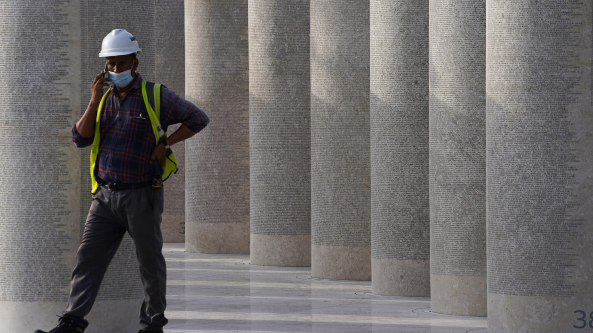 Un trabajador habla por teléfono junto a una instalación que rinde homenaje a los trabajadores extranjeros que construyeron la Expo 2020 en Dubai, Emiratos Árabes Unidos, el 3 de octubre de 2021. (AP Photo/Jon Gambrell, Archivo)