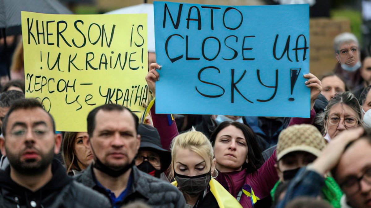 Manifestantes sostienen pancartas en las que se lee “¡Kherson es Ucrania!” y “OTAN, cierra el cielo de Ucrania” durante una manifestación en apoyo a Ucrania y para protestar contra la invasión rusa del país, en la plaza Catalunya de Barcelona, el 6 de marzo de 2022. (Foto de LLUIS GENE / AFP)