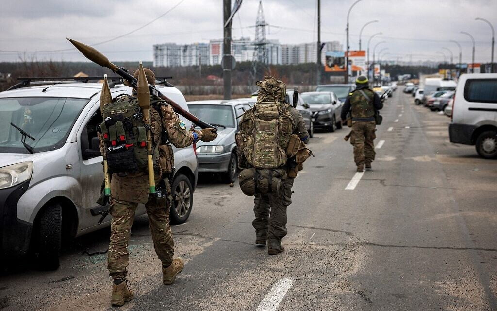 Militares ucranianos portan granadas propulsadas por cohetes y rifles de francotirador mientras caminan hacia la ciudad de Irpin, al noroeste de Kiev, el 13 de marzo de 2022. (Dimitar Dilkoff/AFP)