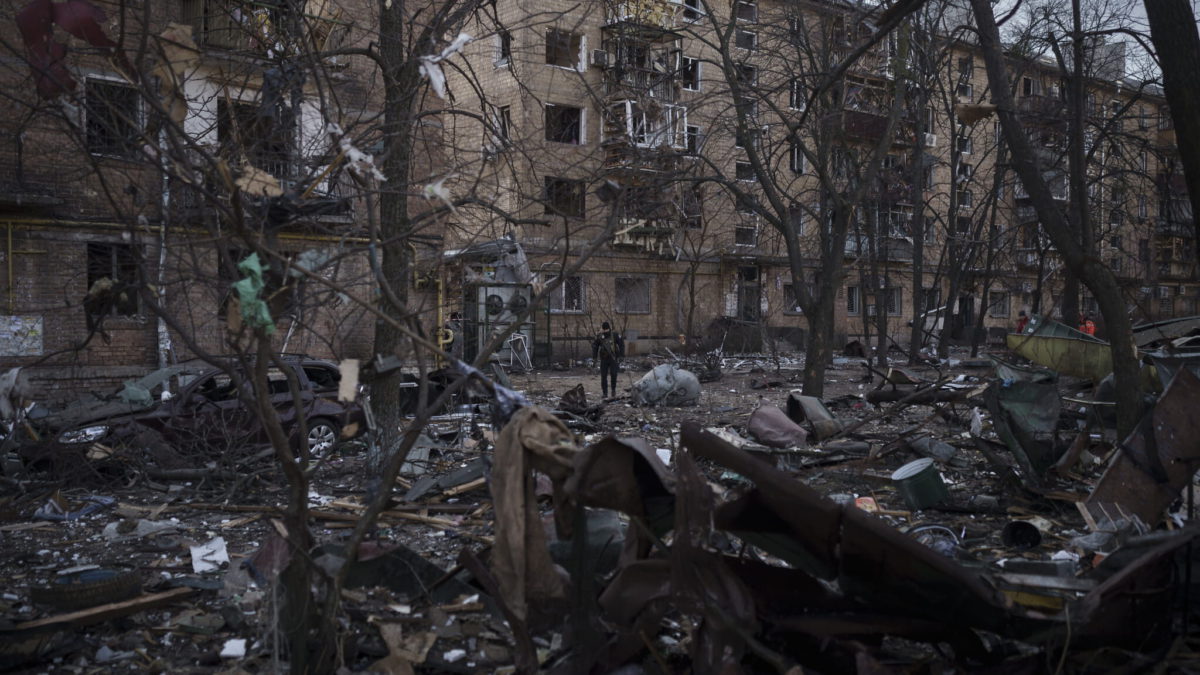Un agente de policía camina por el lugar donde se produjo un atentado que dañó edificios residenciales en Kiev, Ucrania, el 18 de marzo de 2022. (AP Photo/Felipe Dana)