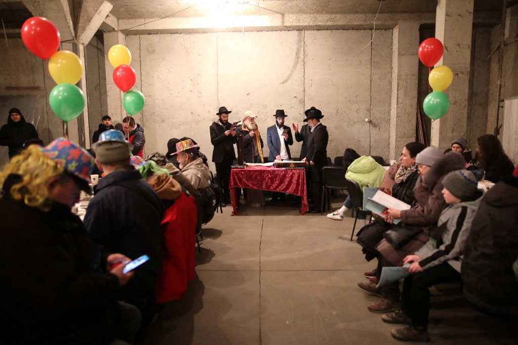 Ilustrativo: Refugiados judíos ucranianos que huyeron de la guerra se reúnen para leer el libro de Ester durante la fiesta judía de Purim en la sinagoga Chabad-Lubavitch en Chisinau, Moldavia, el 16 de marzo de 2022. (Gil Cohen-Magen/AFP)