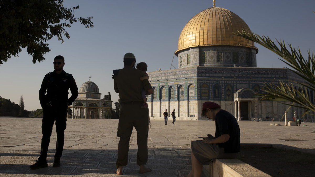Ilustrativo: Un oficial de policía israelí monta guardia mientras un judío religioso con uniforme del ejército visita el Monte del Templo, conocido por los musulmanes como el Noble Santuario, en la Ciudad Vieja de Jerusalén el 3 de agosto de 2021. (AP Photo/ Maya Alleruzzo)