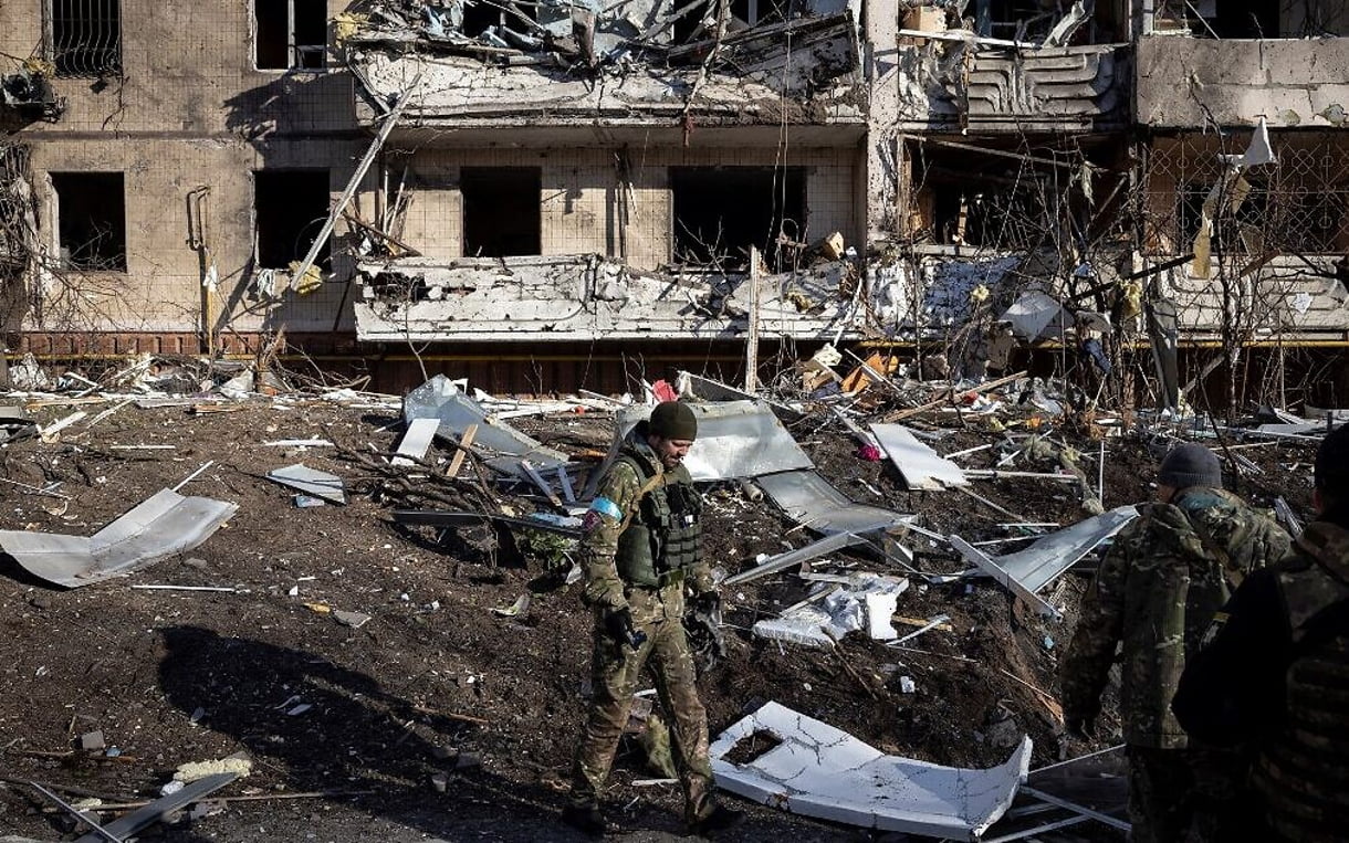 Un soldado ucraniano inspecciona los escombros de un edificio de apartamentos destruido en Kiev el 15 de marzo de 2022, tras los ataques a zonas residenciales. (Fadel Senna/AFP)