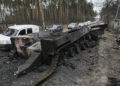 Unos coches pasan por delante de un tanque ruso destruido mientras un convoy de vehículos que evacúan a los civiles sale de Irpin, en las afueras de Kiev, Ucrania, el 9 de marzo de 2022. (AP Photo/Vadim Ghirda, Archivo)