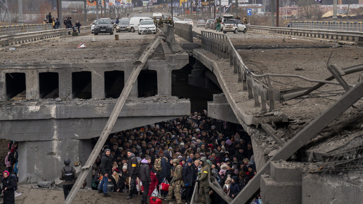 Ucranianos se agolpan bajo un puente destruido mientras intentan huir cruzando el río Irpin en las afueras de Kiev, Ucrania, el 5 de marzo de 2022. (AP Photo/Emilio Morenatti)