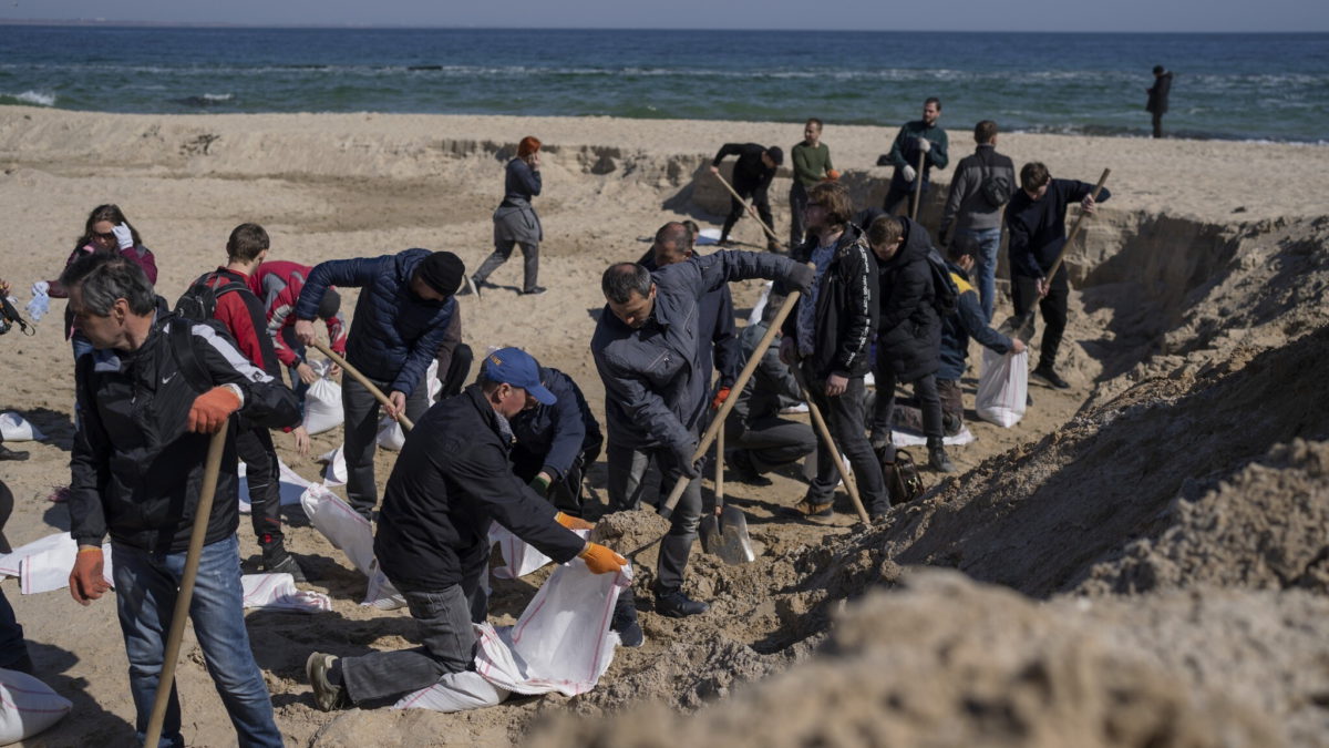 Voluntarios en una playa de arena llenan sacos de arena para defender su ciudad, en Odesa, sur de Ucrania, el 23 de marzo de 2022. (Petros Giannakouris/AP)