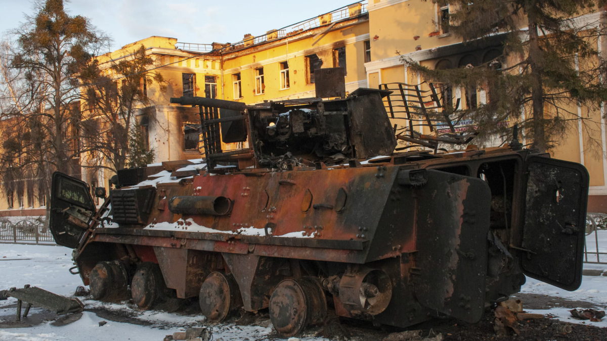 Un vehículo blindado de transporte de personal destruido frente a un edificio dañado por los bombardeos en Kharkiv, Ucrania, el 11 de marzo de 2022. (AP Photo/Andrew Marienko)