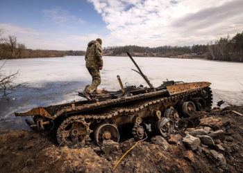 Un militar ucraniano se encuentra cerca de un tanque ruso destruido en la ciudad nororiental de Trostyanets, el 29 de marzo de 2022. (FADEL SENNA / AFP)