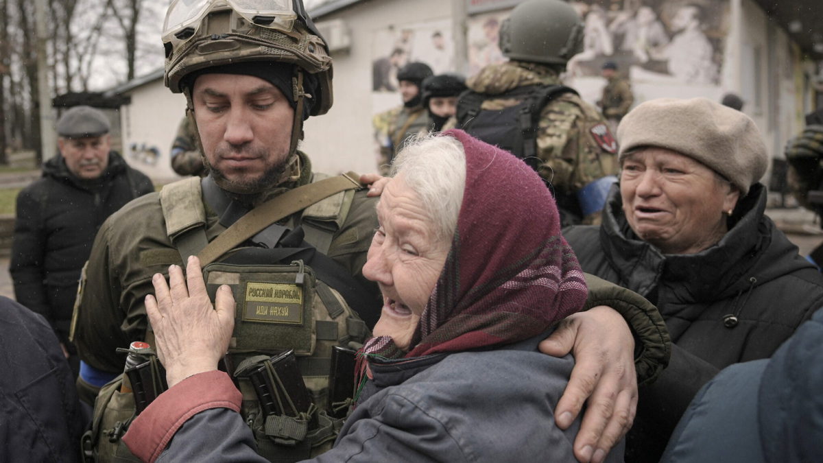 Una mujer abraza a un militar ucraniano después de que un convoy de vehículos militares y de ayuda llegara al suburbio de Bucha, Ucrania, antes ocupado por Rusia, el 2 de abril de 2022. (AP Photo/Vadim Ghirda)