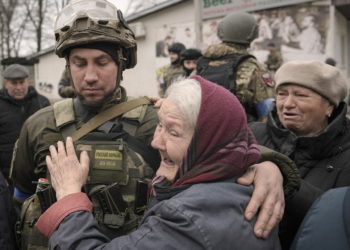 Una mujer abraza a un militar ucraniano después de que un convoy de vehículos militares y de ayuda llegara al suburbio de Bucha, Ucrania, antes ocupado por Rusia, el 2 de abril de 2022. (AP Photo/Vadim Ghirda)