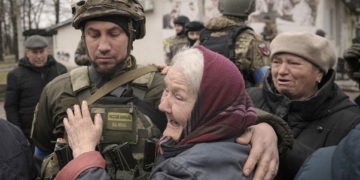 Una mujer abraza a un militar ucraniano después de que un convoy de vehículos militares y de ayuda llegara al suburbio de Bucha, Ucrania, antes ocupado por Rusia, el 2 de abril de 2022. (AP Photo/Vadim Ghirda)