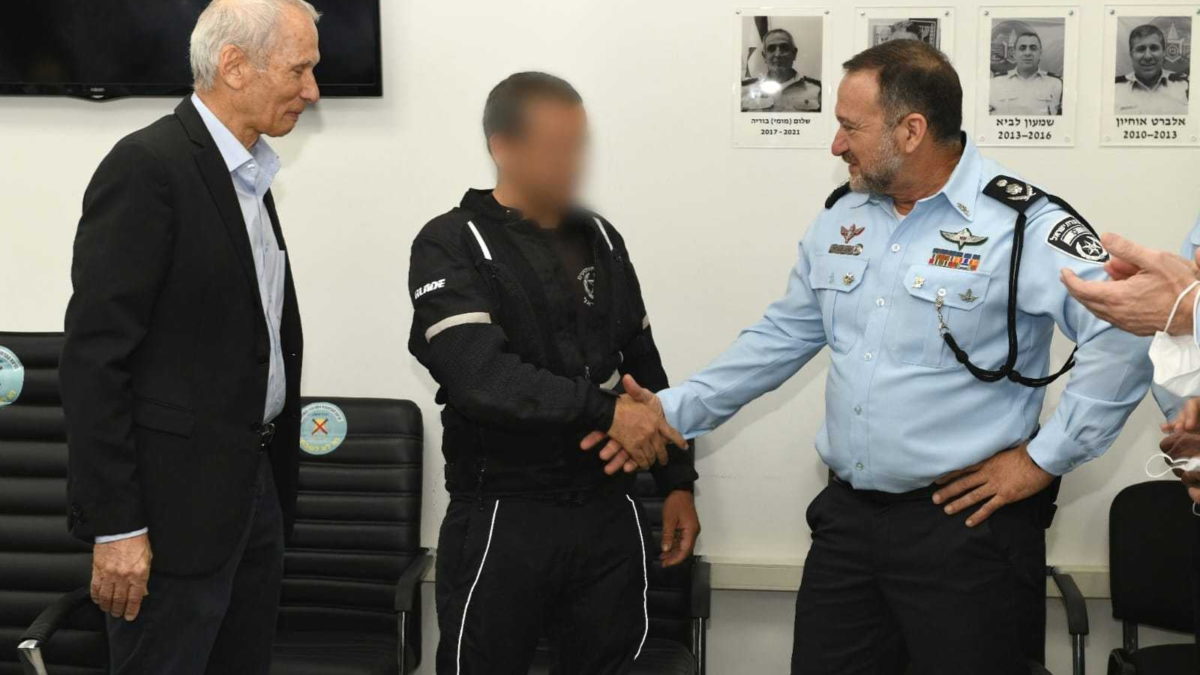 El ministro de Seguridad Pública, Omer Barlev (izquierda), y el comisario de la Policía de Israel, Kobi Shabtai (derecha), elogian al policía que ayudó a matar a tiros a un terrorista en Bnei Brak la semana pasada, el 5 de abril de 2022. (Policía de Israel)