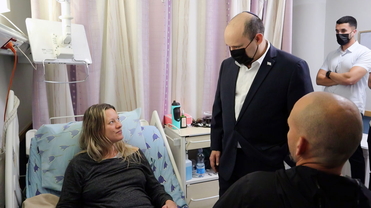El primer ministro Naftali Bennett visita a las víctimas de un tiroteo terrorista en Tel Aviv, en el hospital Ichilov, el 9 de abril de 2022. (Cortesía)