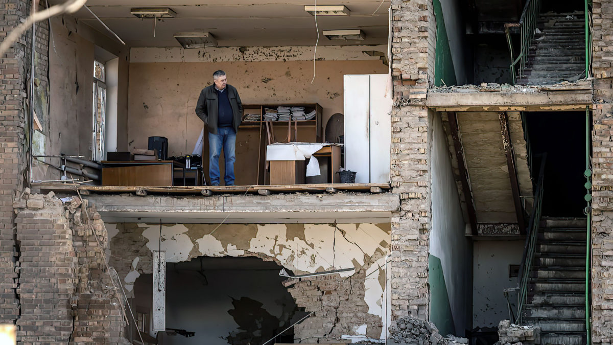 Un hombre se encuentra en un edificio con la fachada derrumbada en el complejo militar-industrial de la empresa Vizar, después de que el sitio fue golpeado por los ataques rusos durante la noche, en la ciudad de Vyshneve, suburbios del suroeste de Kiev, el 15 de abril de 2022 (FADEL SENNA / AFP)