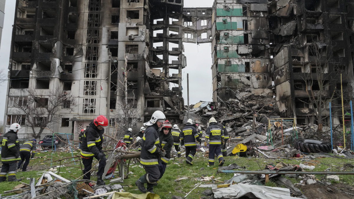 Trabajadores de emergencia llevan los escombros de un edificio de varios pisos destruido en un ataque aéreo ruso al comienzo de la guerra entre Rusia y Ucrania en Borodyanka, cerca de Kiev, Ucrania, 9 de abril de 2022. (AP Photo/Efrem Lukatsky)