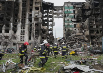Trabajadores de emergencia llevan los escombros de un edificio de varios pisos destruido en un ataque aéreo ruso al comienzo de la guerra entre Rusia y Ucrania en Borodyanka, cerca de Kiev, Ucrania, 9 de abril de 2022. (AP Photo/Efrem Lukatsky)