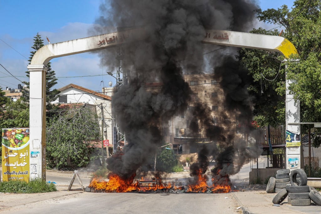 Neumáticos son incendiados en una entrada de Jenín el 9 de abril de 2022 (JAAFAR ASHTIYEH / AFP)