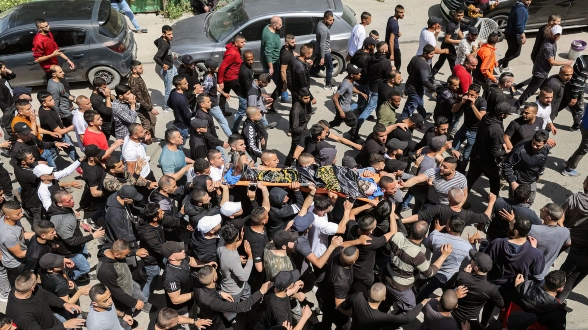 Los dolientes llevan el cuerpo del miembro de la Yihad Islámica Ahmed as-Saadi, que murió durante un tiroteo con las tropas israelíes en el campo de refugiados de Jenin, en Cisjordania, el 9 de abril de 2022. (Jaafar Ashtiyeh/AFP)