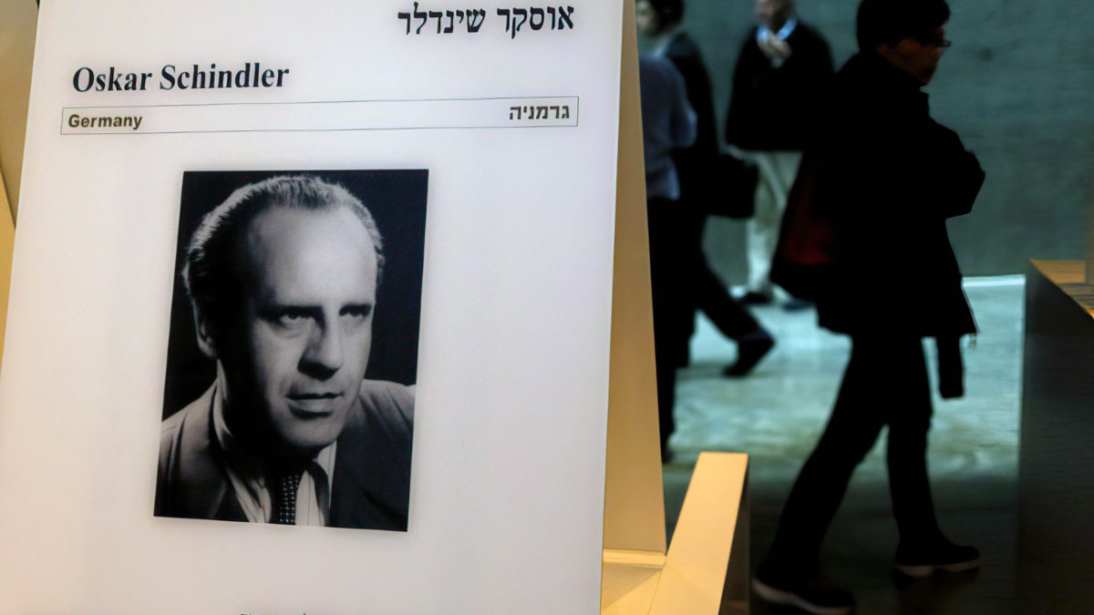 Los visitantes pasan por delante de un retrato de Oskar Schindler en el museo conmemorativo del Holocausto Yad Vashem en Jerusalén, el 4 de marzo de 2015. (Foto: AFP / GALI TIBBON)