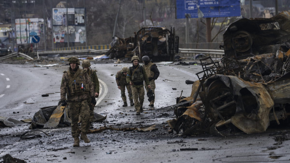 Soldados ucranianos caminan junto a vehículos blindados rusos destruidos en Bucha, Ucrania, el sábado 2 de abril de 2022. (AP Photo/Rodrigo Abd)