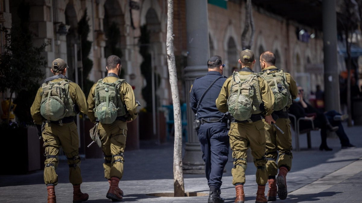 Un oficial de policía camina con soldados de las FDI mientras patrullan en Jerusalén el 1 de abril de 2022, tras varios ataques terroristas recientes. (Yonatan Sindel/Flash90)