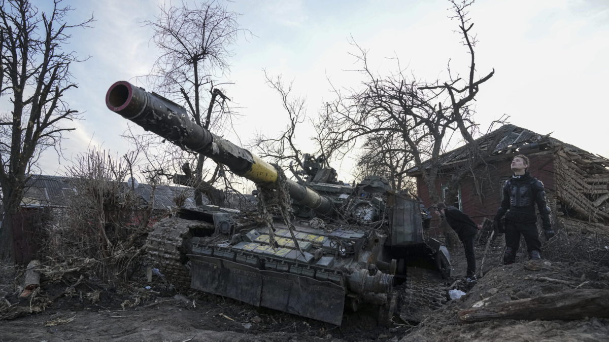 Hombres junto a un tanque destruido en Chernihiv, Ucrania, el jueves 7 de abril de 2022. (AP/Evgeniy Maloletka)