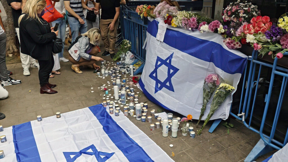 Los israelíes se reúnen en el lugar de un ataque a tiros la noche anterior en la calle Dizengoff en Tel Aviv el 8 de abril de 2022. (Jack Guez / AFP)