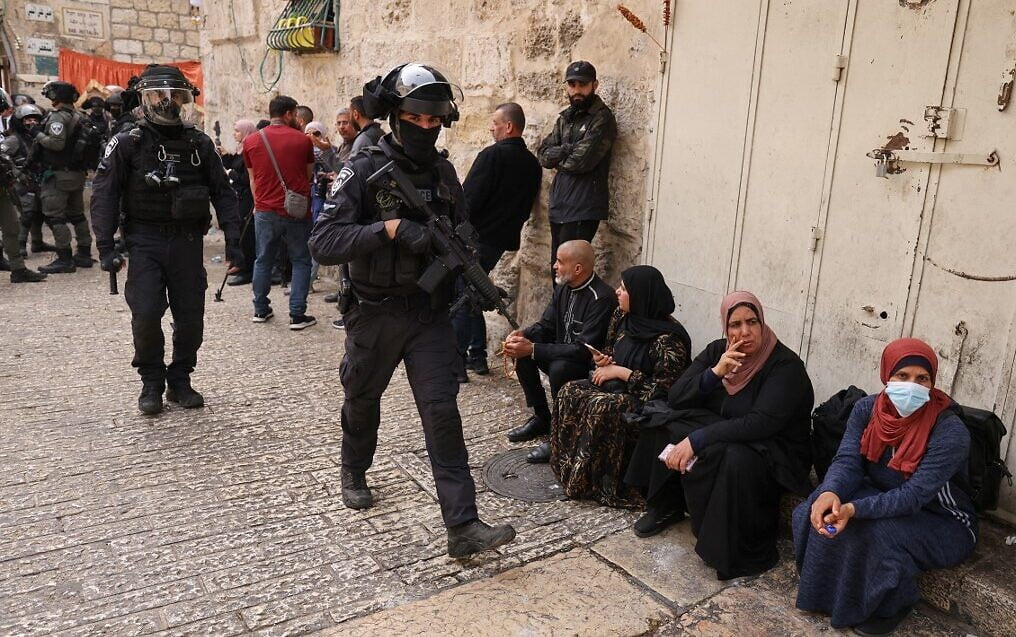 La policía fronteriza israelí patrulla cerca de la Puerta del León en la Ciudad Vieja de Jerusalén, mientras los palestinos esperan para entrar en el recinto del Monte del Templo, el 17 de abril de 2022. (Ahmad Gharabli/AFP)