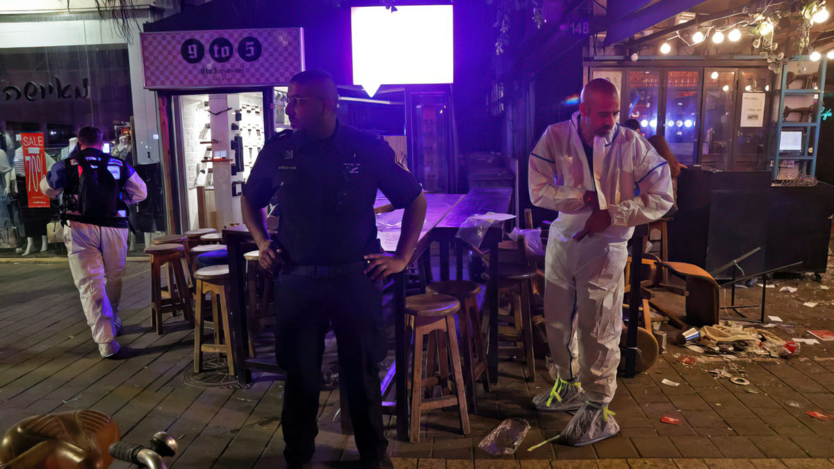 La policía y los expertos forenses en la escena de un ataque terrorista mortal en un café en la calle Dizengoff en Tel Aviv el 7 de abril de 2022. (Jack Guez / AFP)