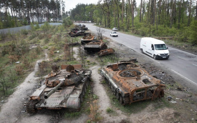Coches pasan junto a tanques rusos destruidos en una reciente batalla contra los ucranianos en la aldea de Dmytrivka, cerca de Kiev, Ucrania, el 23 de mayo de 2022. (AP Photo/Efrem Lukatsky, Archivo)