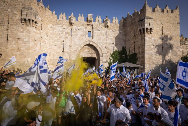Miles de judíos ondean banderas israelíes mientras celebran el Día de Jerusalén en la Puerta de Damasco, en la Ciudad Vieja de Jerusalén, el 29 de mayo de 2022. (Nati Shohat/Flash90)