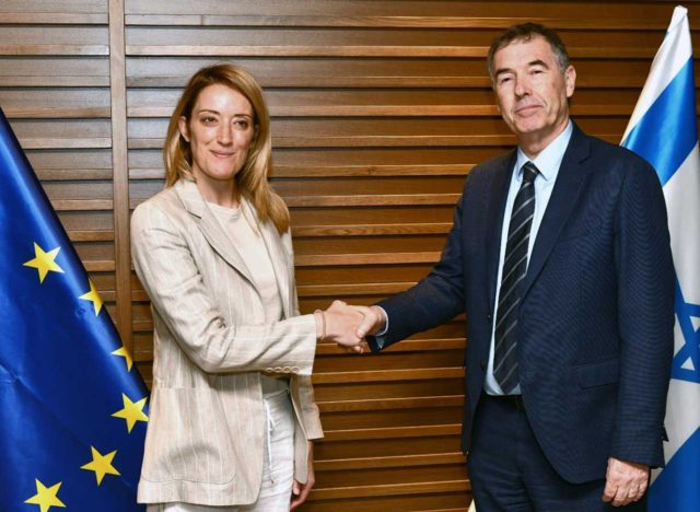 La presidenta del Parlamento Europeo, Roberta Metsola (izquierda), estrecha la mano de Yisrael Beytenu MK Yossi Shain tras llegar a Israel el 22 de mayo de 2022. Avi Hayoun/MFA)